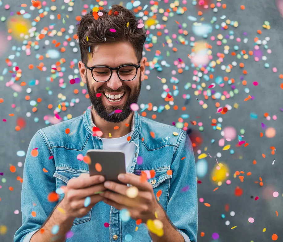 Crea Energía — smiling customer checking his energy app amid confetti